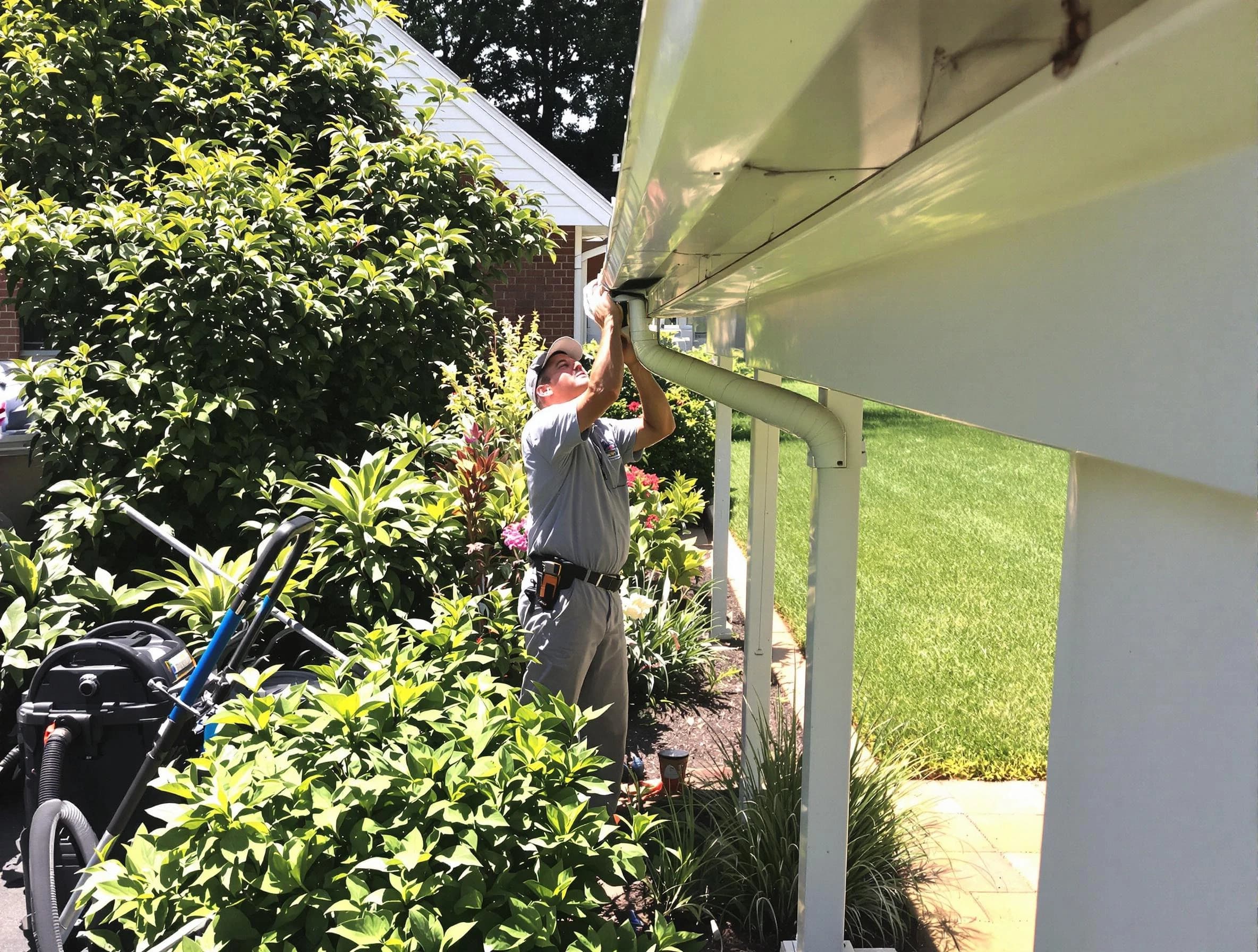 Technician flushing a blockage from a downspout in Berea, OH